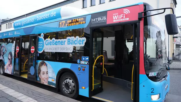 Auf dem Bild sieht man einen Bus der MIT.BUS GmbH der mit Werbung für die Gießener Bäder beklebt wurde.